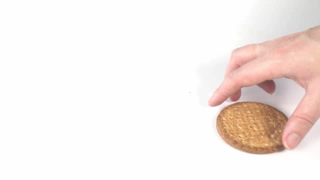 Female hand taking grabbing normal freshly baked grain cookie, healthy snack on white background copy space, bad unhealthy choice