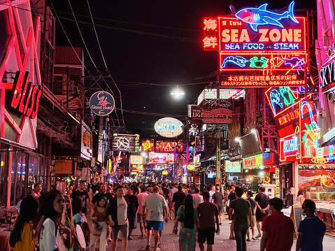 Crowd of tourists and locals on the famous walking street, a hot night strip with many bars and nightclubs in Pattaya, Thailand.