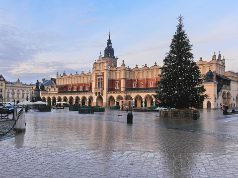 Krakow, Poland - 01 02 2023 : Winter view of Clothes hall (Sukiennice) at sunset. A christmas tree stands close to it.