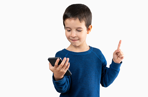 Child texting using a smartphone over isolated background very happy pointing hand and finger to the side