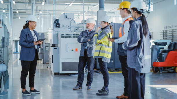istock Factory Meeting: Black Female Chief Engineer Talking to Colleagues Before Work Day in Heavy Industry Manufacturing Facility. Diverse Group of Employees Listening to Manager. 1462124625
