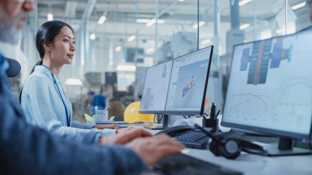 istock Factory Office Facility: Industrial Engineer Drafting Blueprints of a Heavy Industry Machine Parts on a Computer CAD Software. Modern Technological Industry 4.0 Research and Development Center. 1462125759