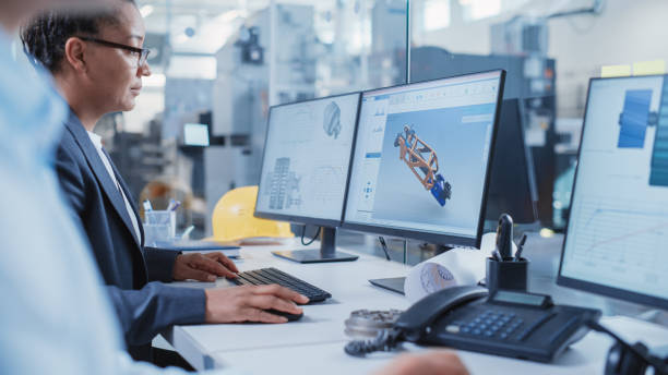 istock Factory Office Facility: Industrial Engineers Drafting Blueprints of a Heavy Industry Machine Parts on a Computer CAD Software. Modern Technological Industry 4.0 Research and Development Center. 1462127043