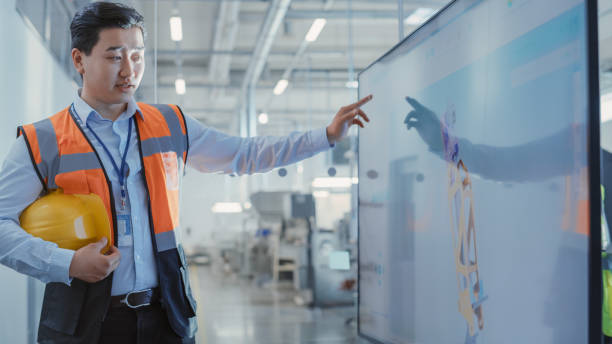 istock Factory Office Meeting: Asian Facility Director Talking and Explaining in a Conference Room with TV Set. Heavy Industry Employee Discussing Modern Hydraulics Mechanism for Industry Equipment. 1462128203