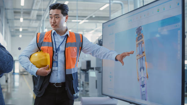 istock Factory Office Meeting: Asian General Manager Talking with Chief Engineer in a Conference Room with TV Set. Heavy Industry Employees Discussing Modern Hydraulics Mechanism for Industry Equipment. 1462128237