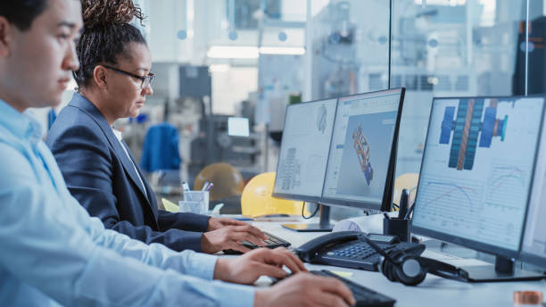 istock Factory Office Room: Industrial Engineers Developing Models of a Heavy Industry Machine Parts on a Computer 3D Software. Modern Technological Industry 4.0 Research and Development Center. 1462131658