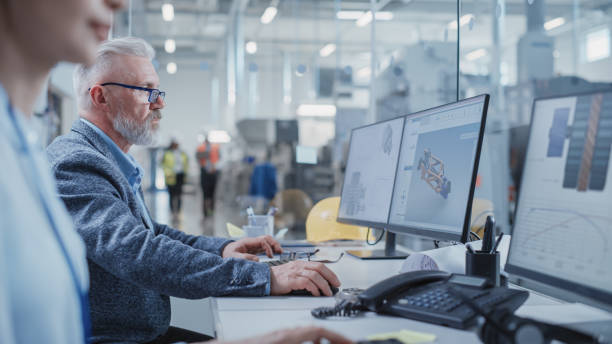 istock Portrait of a Middle Aged Industrial Engineer Developing Models of a Heavy Industry Machine Parts on Computer 3D Software in a Factory. Modern Technological Research and Development Center. 1462134867
