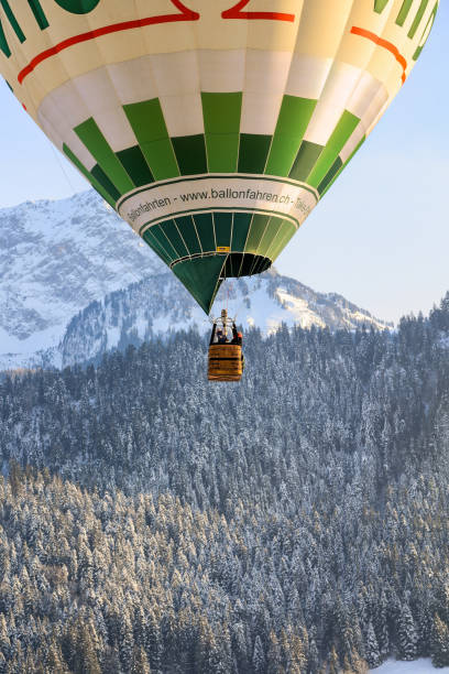 um balão de ar quente em ascensão em cloaseup voando e flutuando sobre os alpes suíços - traditional festival adventure air air vehicle - fotografias e filmes do acervo