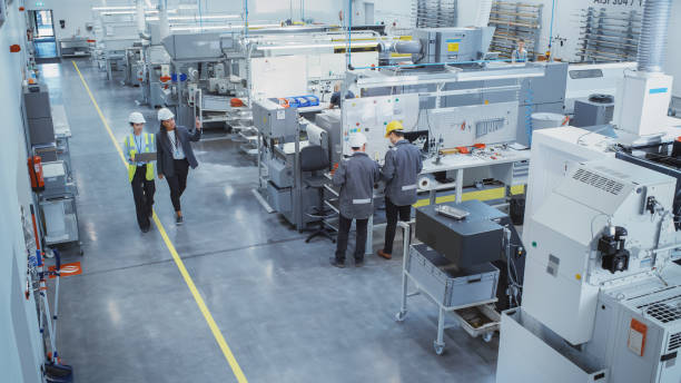 istock Industrial Factory: Diverse Multiethnic Team of Engineers, Technicians, Specialists and Workers, Working on Production Plant, Developing CNC Parts, Programming Machines, Executing Orders. 1462146800