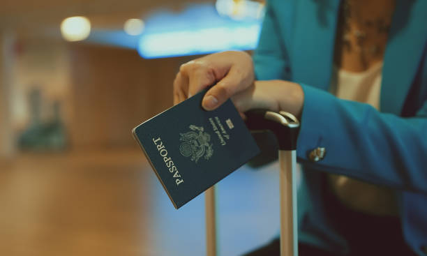 Woman with USA passport is waiting for her flight at the airport. stock photo