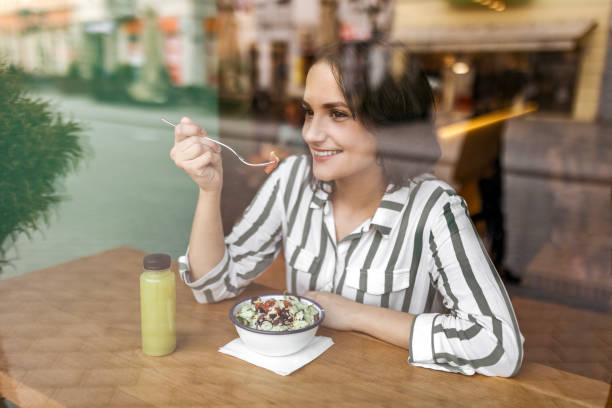 istock Woman sitting at a restaurant eating salad 1462148270
