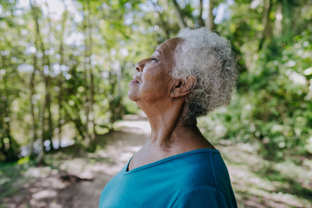 ritratto di una donna anziana che respira aria fresca - inspirare foto e immagini stock
