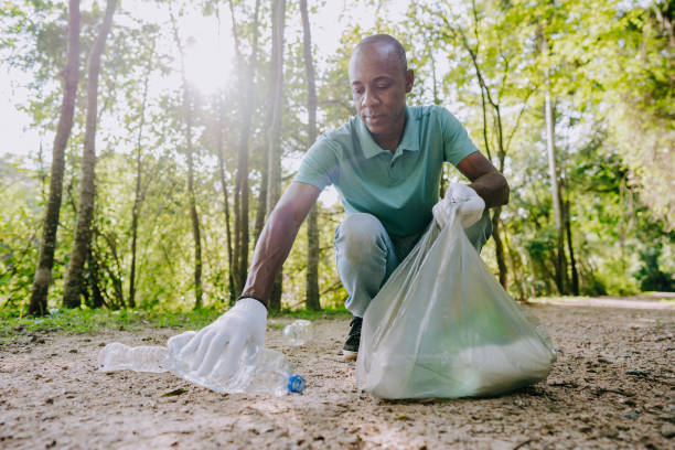 a man picking up garbage in nature