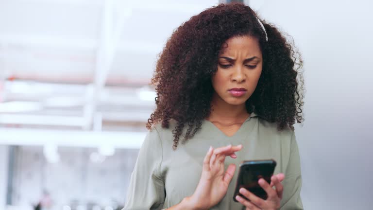 Phone, black woman and frustrated frown of a person on digital communication reading fake news. Annoyed woman on web, internet and social media scroll confused about digital media reading in a office