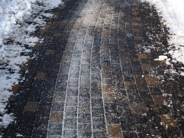 istock Salt grains on icy sidewalk surface in the winter 1462171286