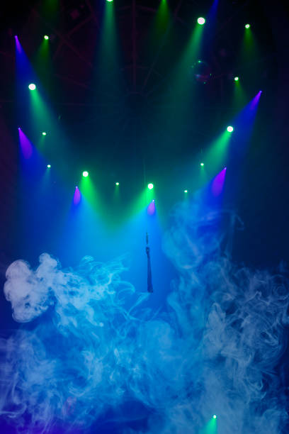 istock Blue stage circus smoke and green beams from projectors on a blue vertical background. 1462172105