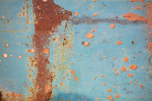 The texture of a rusty iron surface is painted with blue paint.