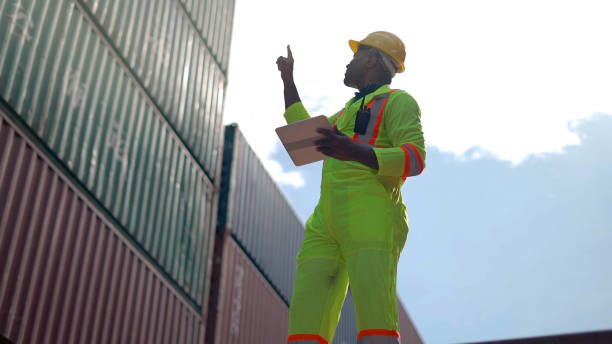 Foreman use walkie talkie to communicate and control staff shipment in container shipping area. stock photo