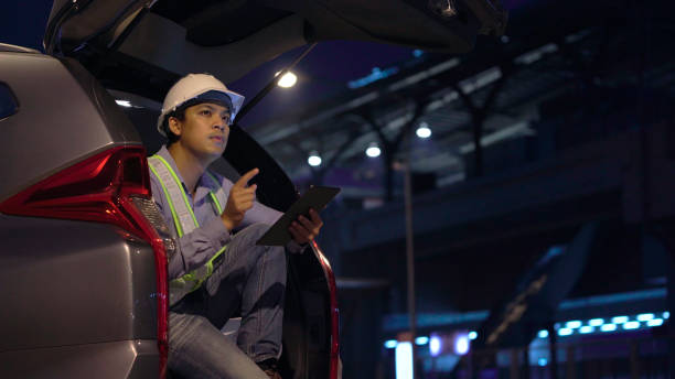 Civil engineer work inspecting architect drawing on construction site. stock photo