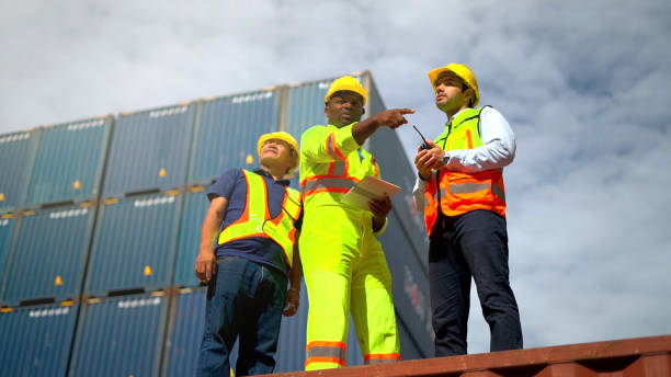 istock Logistic staff checking data to survey and inspect stack container in shipment company area. 1462175479