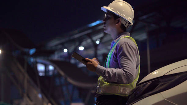 Civil engineer work inspecting architect drawing on construction site. stock photo