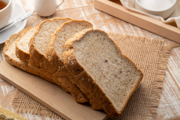 istock Sliced whole wheat bread on wooden cutting board 1462182804