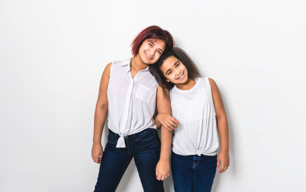 portrait of two beautiful sister over studio background A portrait of two beautiful sister over studio background child 10 11 years 8 9 years cheerful stock pictures, royalty-free photos & images