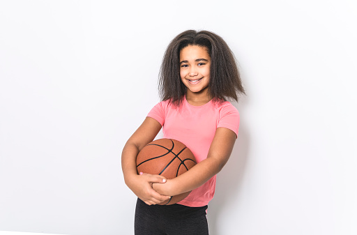 A Studio shot of young girl, basketball player over white background