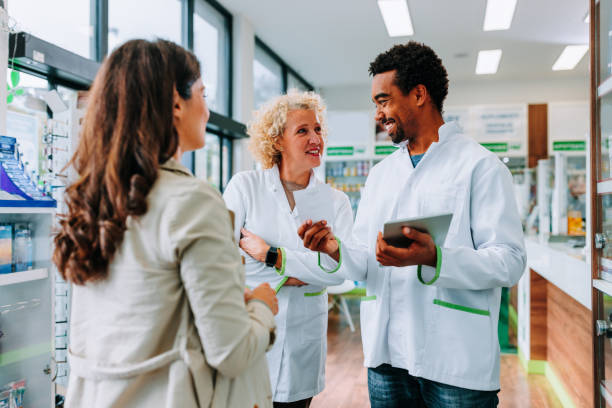 istock Joyful pharmacist coworkers with client. 1462188106