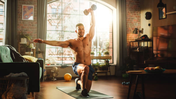 Portrait of a Strong Athletic Black Man Doing Shirtless Workout at Home, Training with Dumbbells. Fit Muscular Sportsman Staying Healthy, Training at Home. Sweat, Determination. Low Angle Portrait of a Strong Athletic Black Man Doing Shirtless Workout at Home, Training with Dumbbells. Fit Muscular Sportsman Staying Healthy, Training at Home. Sweat, Determination. Low Angle home workout stock pictures, royalty-free photos & images