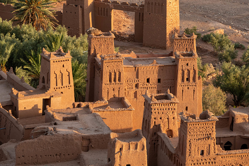 The Ksar of Aït-Ben-Haddou - a group of mud-brick houses surrounded by high walls - is a good example of a traditional living environment in the Pre-Saharan region south of the Atlas Mountains. The houses are close together within defensive walls reinforced by corner towers. Some houses are modest, others resemble small urban castles with tall corner towers and the upper parts decorated with motifs in brick. Located in Ouarzazate province, Aït-Ben-Haddou gives a good idea of earthen building techniques in pre-Saharan Africa. The oldest structures appear to be no earlier than the 17th century, although their structure and technique were used earlier in the valleys of southern Morocco.