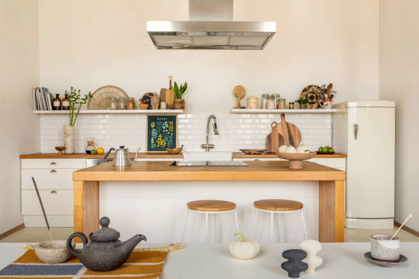 istock Warm and cozy kitchen interior with mock up poster frame, wooden kitchen island, barstool, fridge, white kitchen furniture, gray pitcher, salt cellar and kitchen accessories. Home decor. Template. 1462192501