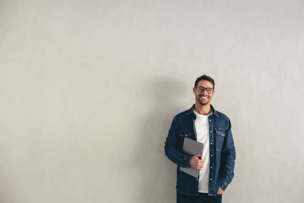 istock Businessman smiling at the camera while holding a laptop 1462193974