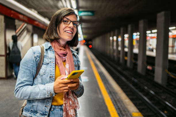 istock Young Woman Using Phone While Waiting For The Subway Train In A Subway Station 1462194015