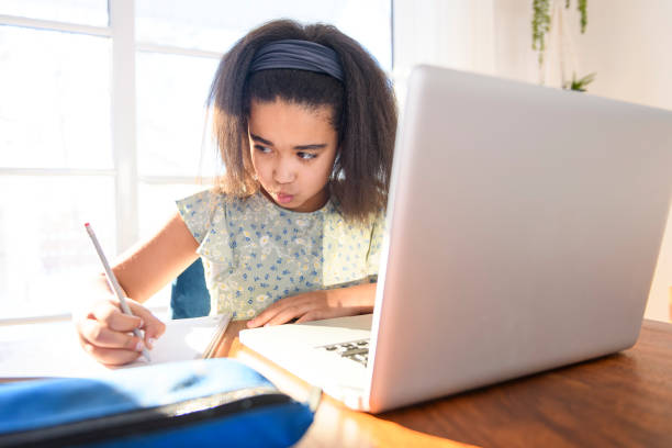 istock portrait of cute child doing homework on kitchen table with laptop 1462198444
