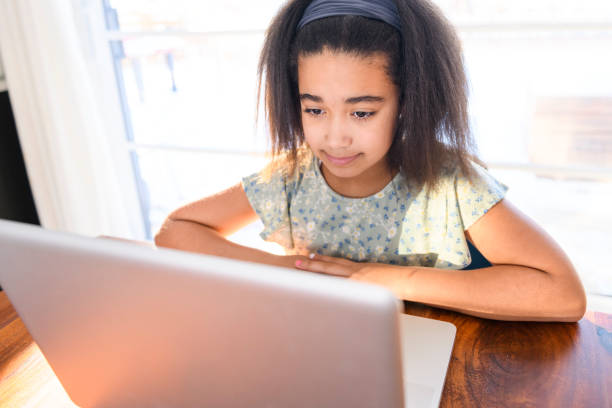istock portrait of cute child doing homework on kitchen table with laptop 1462198460