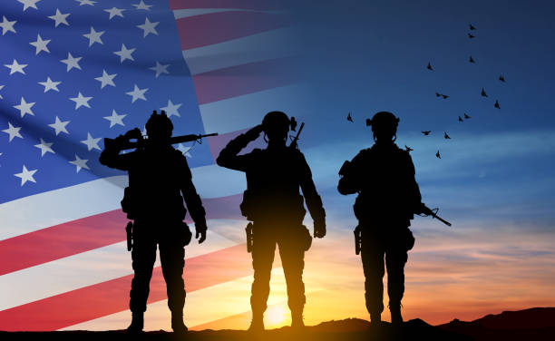 силуэты солдат армии с сша флагом - celebration silhouette back lit sunrise stock illustrations