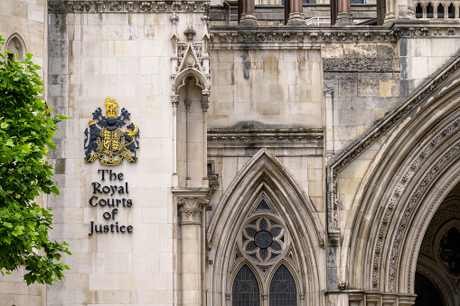 LONDON - May 21, 2022: Coat of Arms and sign on side of The Royal Courts of Justice building