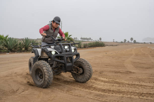 istock Man riding a quad bike in a circle on a beach 1462200864