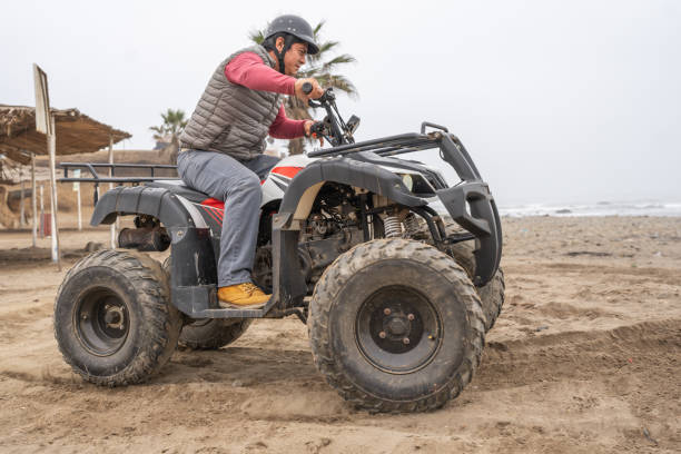 istock Man driving a quad bike along a beach 1462200911