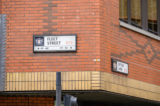 LONDON - May 21, 2022: Fleet Street EC4 and Fetter Lane EC4 street signs on the side of a red brick building