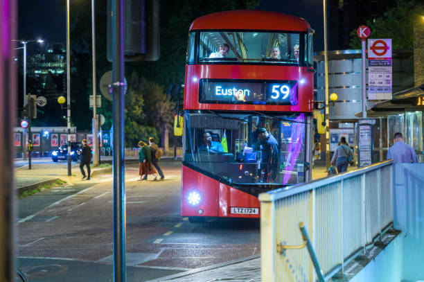 LONDON - May 21, 2022: Passenger paying for bus journey on red Double Decker Bus at night outside Waterloo Station