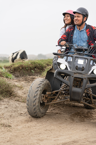 istock Vertical photo of a couple on a quad in a rural road 1462201291