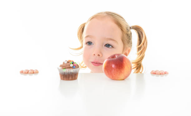 istock Child girl with Cupcake and apple on white background 1462201556