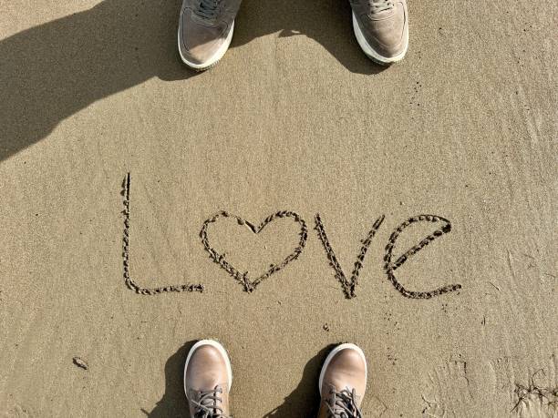 istock hand written love word on sand 1462202320