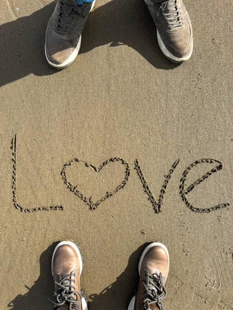 istock hand written love word on sand 1462202325