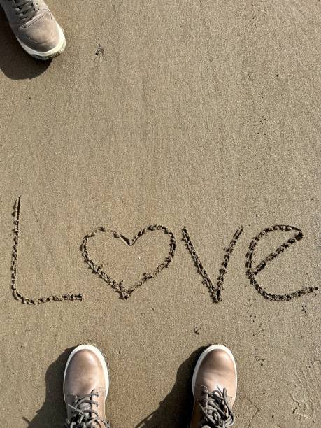 istock hand written love word on sand 1462202326