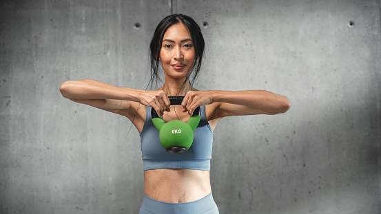 Online Workout Service: Professional Female Trainer Exercises, Video Tutorial, Virtual Training. Strong Fit Asian Woman Coach Teaching, Shows How to Work with Kettlebell. Cinematic Portrait