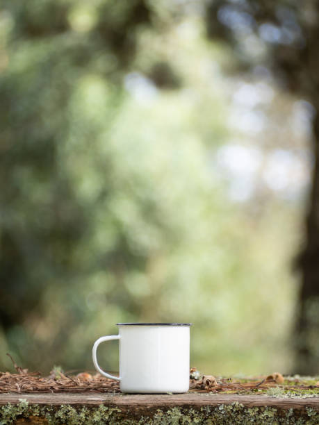 istock White enamel mug isolated on wooden tabletop. Warming drink, outside in the forest. Camping equipment outdoors concept. 1462203055