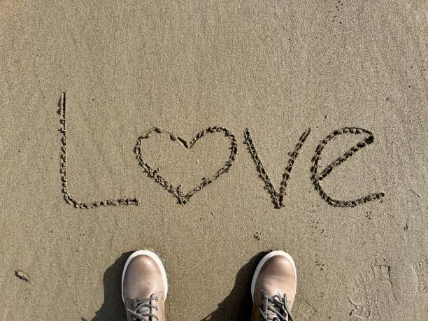 istock shoes on sandy beach with hand written love word 1462203062